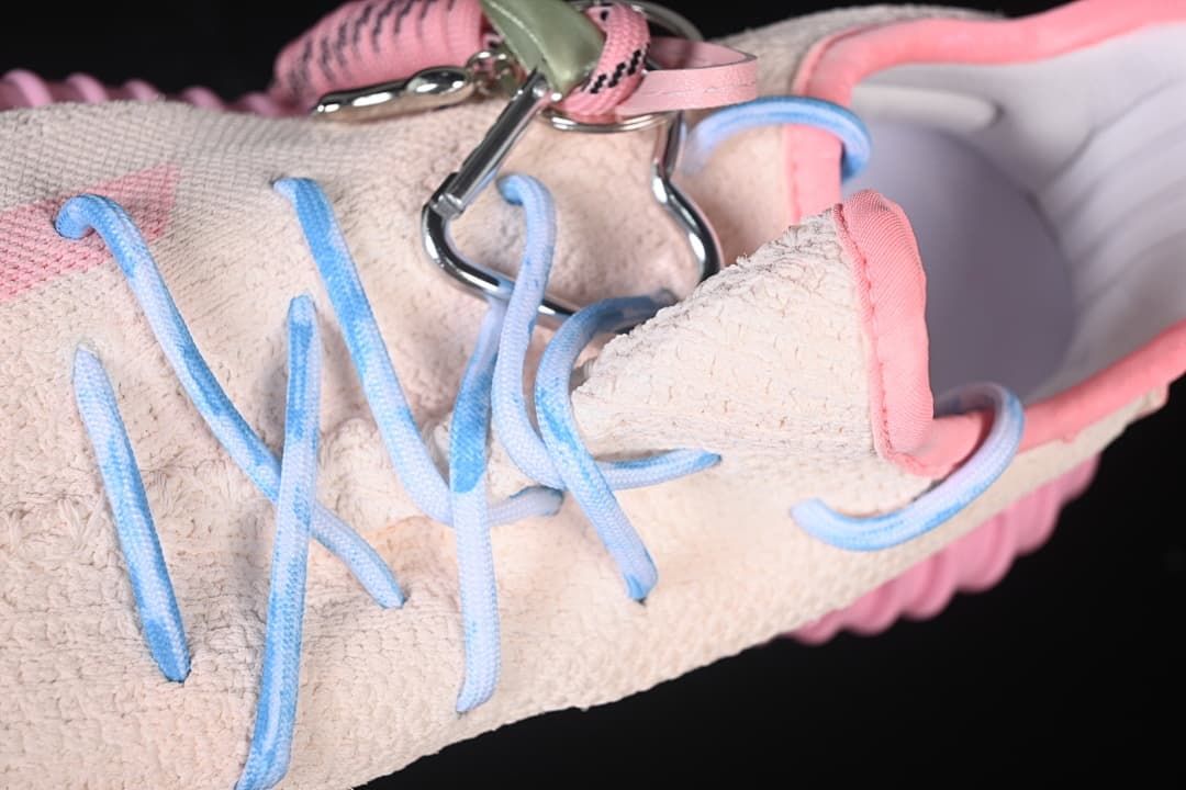 Close-up of blue lacing and the upper, with a decorative charm attached.