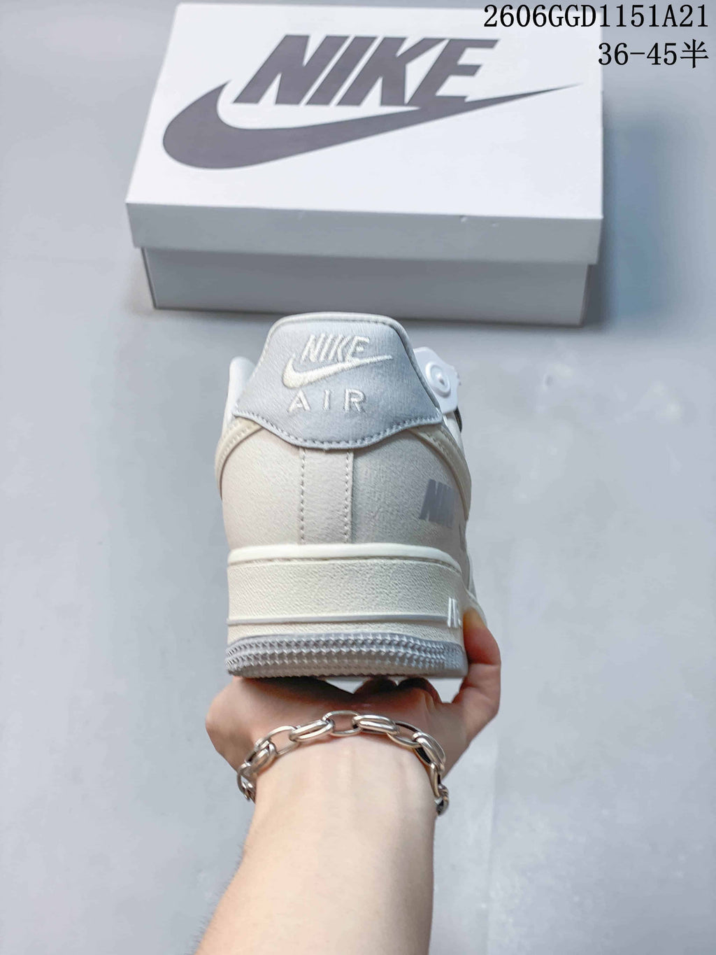 Rear view showing Nike Air branding on the heel of a cream sneaker