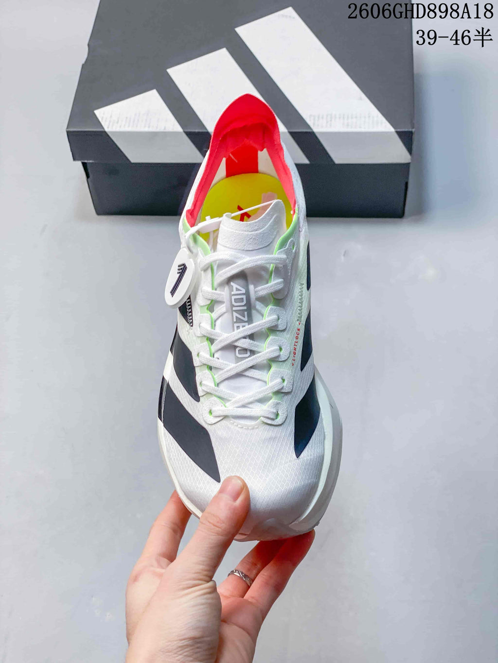 Top view of a white lace-up running shoe with dark side details and red lining.
