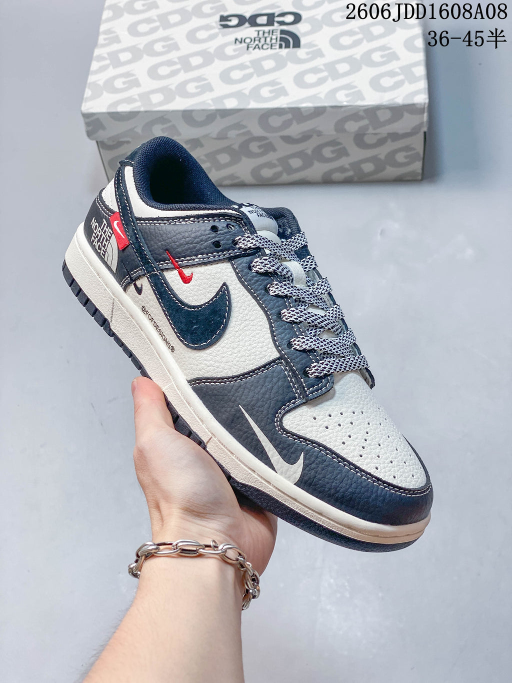 Angled view of the sneaker's side panels, swoosh, and red accent details