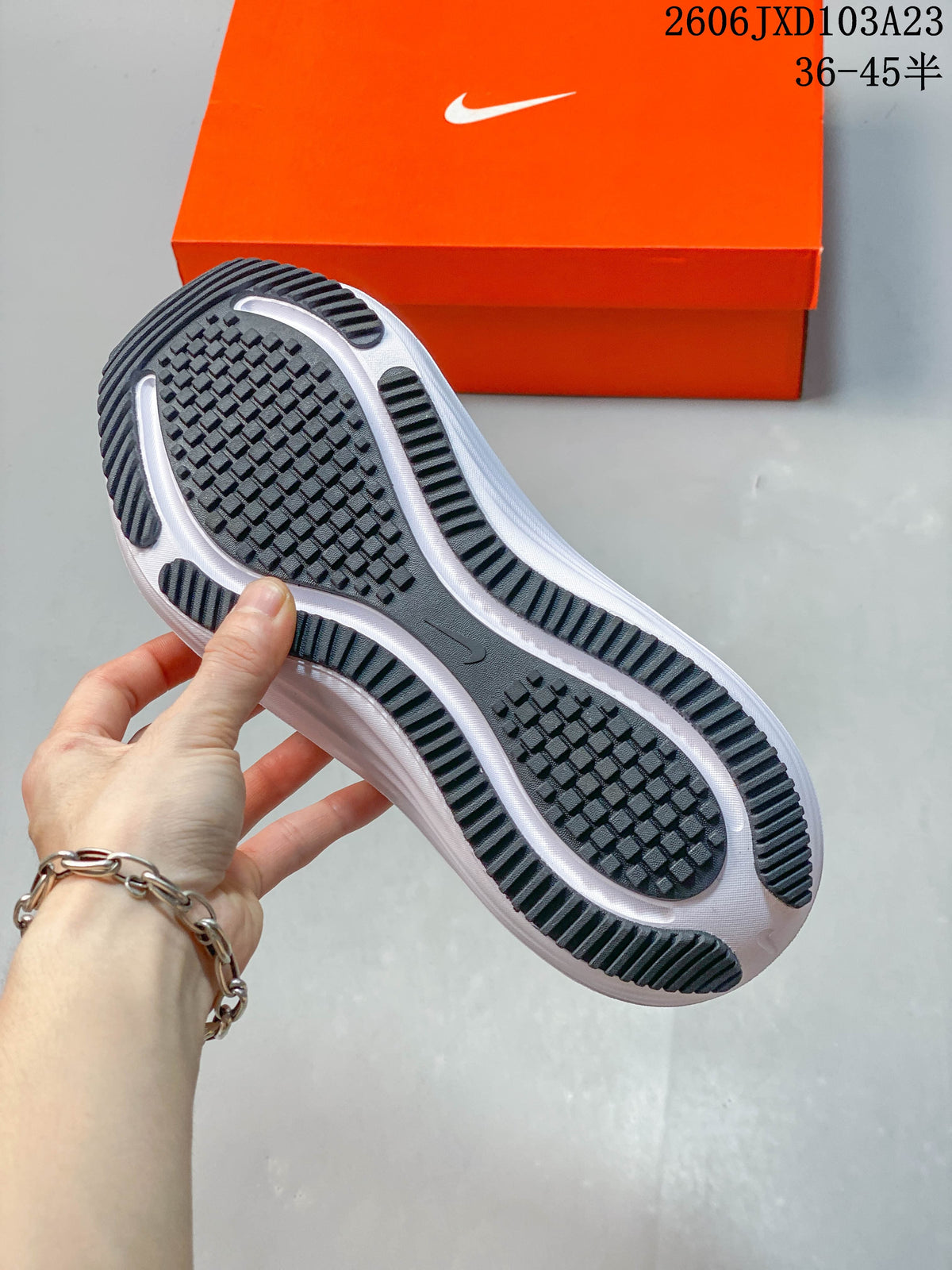 Close-up of the dark treaded outsole of a white running shoe