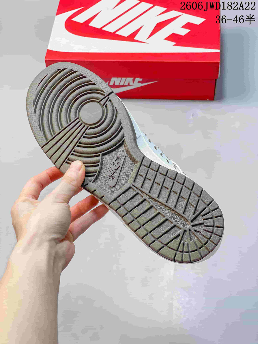 Close-up of the gray outsole with circular tread on a white low-top sneaker