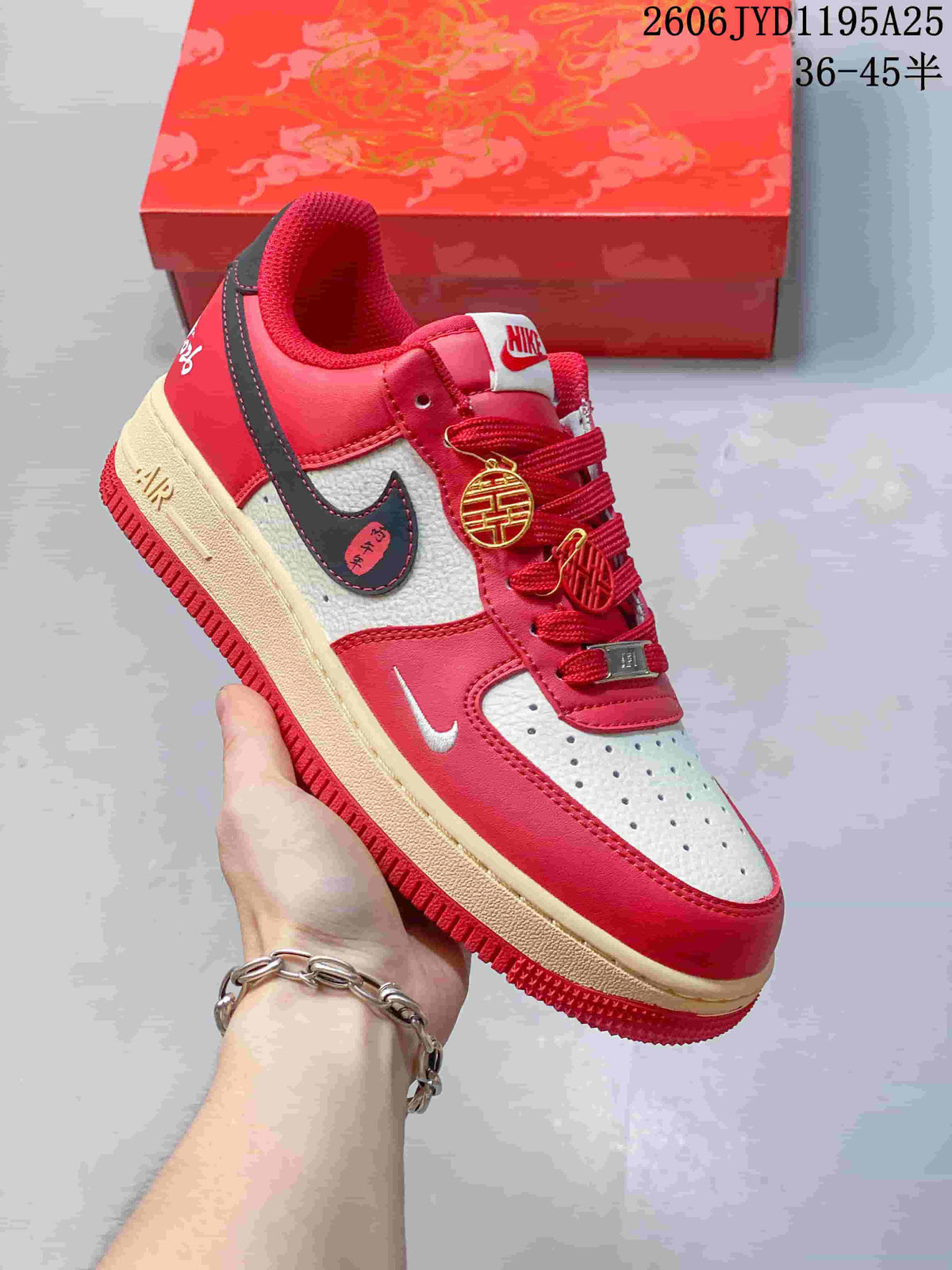 Close view of a red-and-white low-top sneaker with perforated toe and decorative lace charms