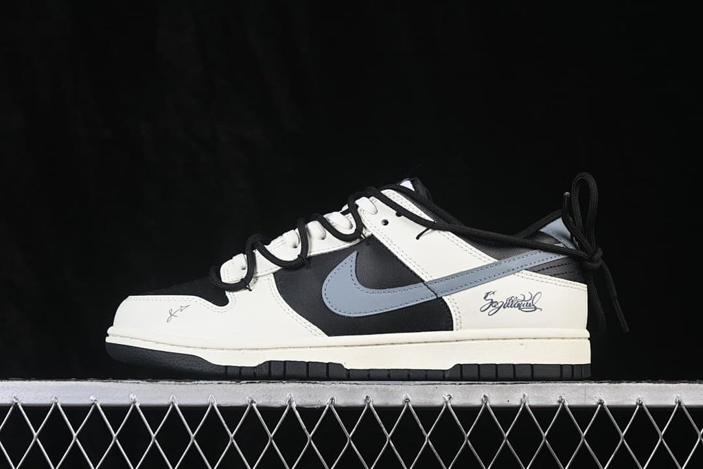 Side view of a black and white low-top sneaker with a gray Swoosh, layered laces, and script side detail
