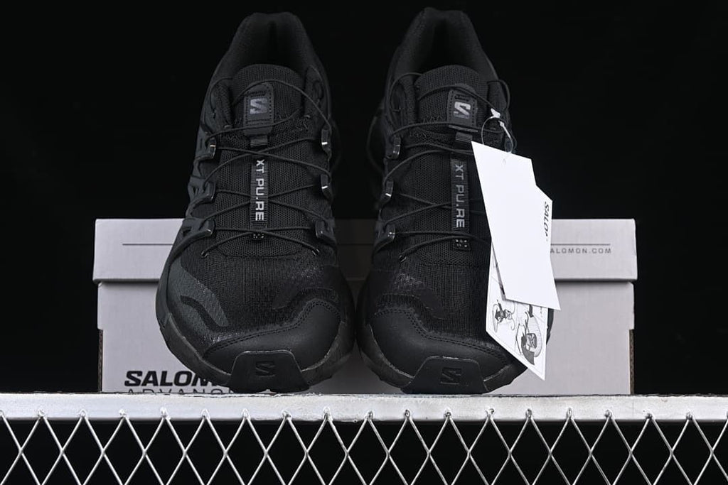 Front view of the pair of black trail shoes on the box.