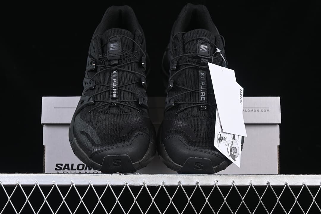 Front view of the pair of black trail shoes on the box.