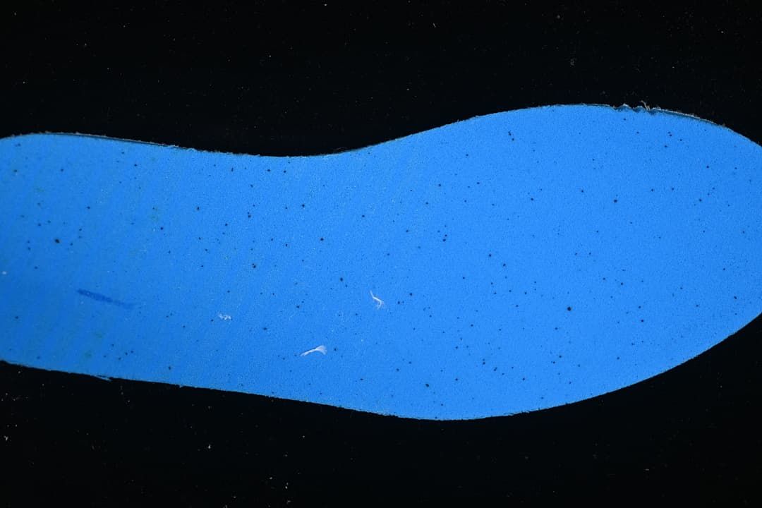 Blue outsole detail photographed under blue lighting.