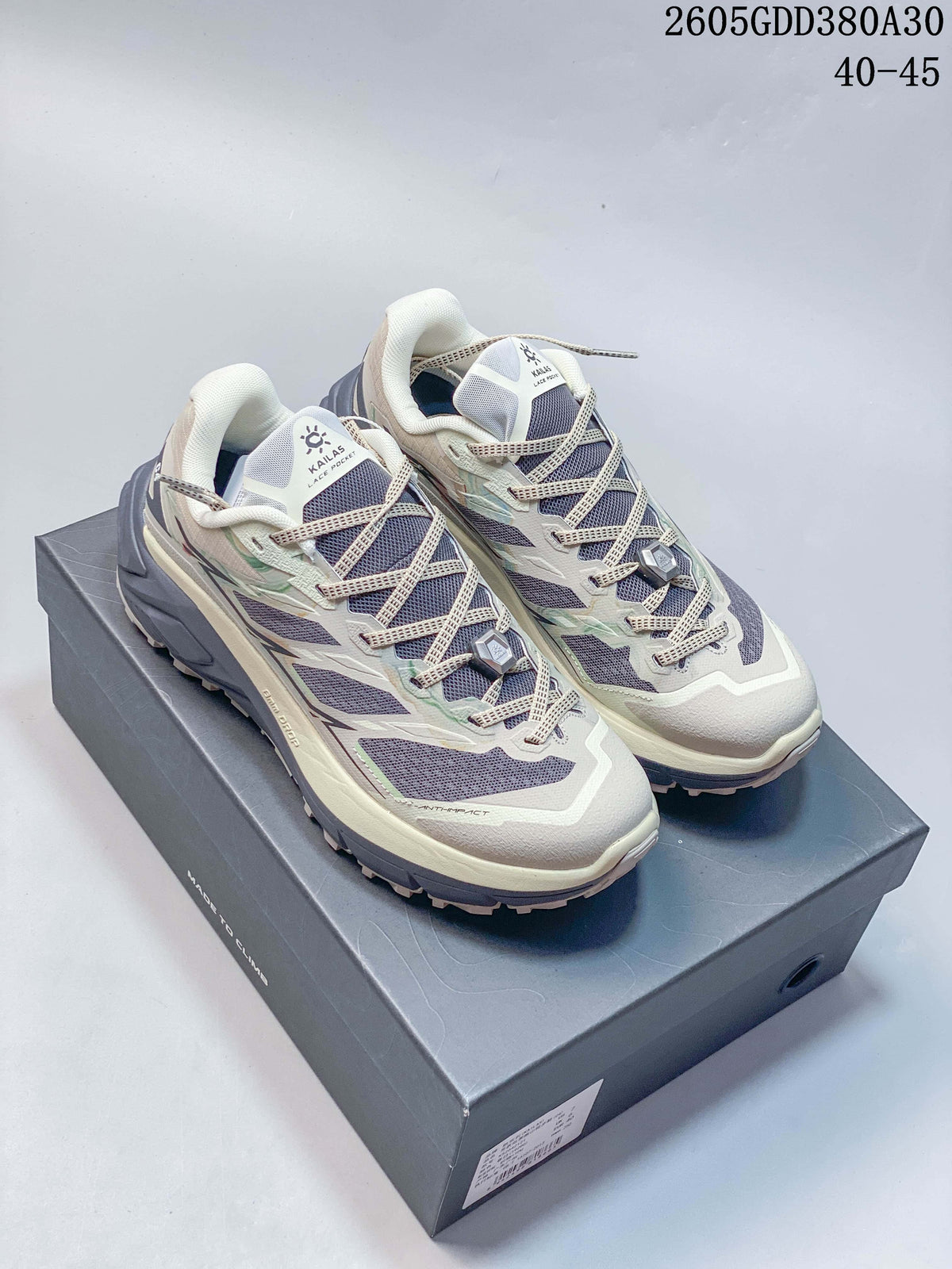 Pair of light-colored Kailas C4 trail running shoes on a shoebox