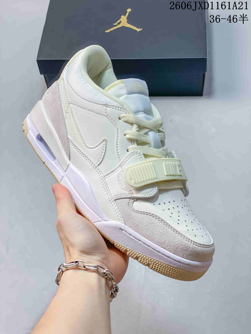 Angled side view of the pale cream and white Jordan Legacy 312 Low sneaker