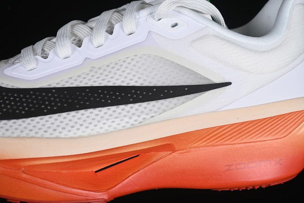 Close-up of the perforated white upper, black Swoosh and orange sole