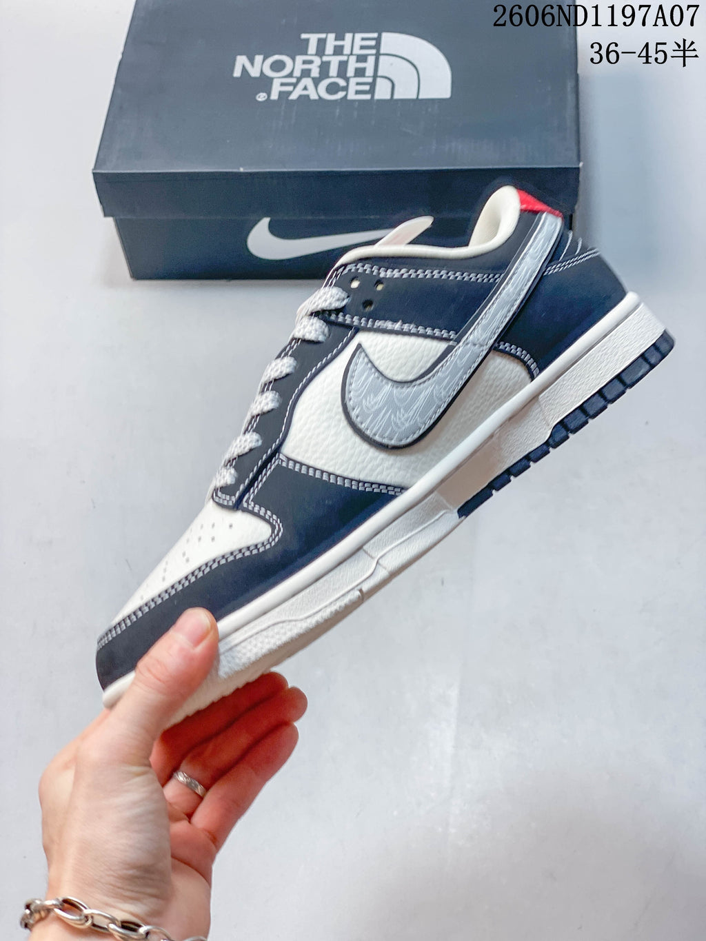 Side view highlighting the patterned gray swoosh, navy overlays, and contrast stitching