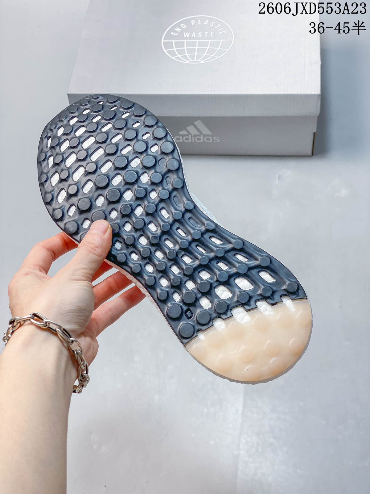 Close-up of the patterned outsole on a white Adidas PureBoost 21 shoe