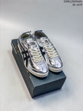 Pair of silver Onitsuka Tiger Mexico sneakers with dark side stripes and cream laces, displayed on a shoe box.