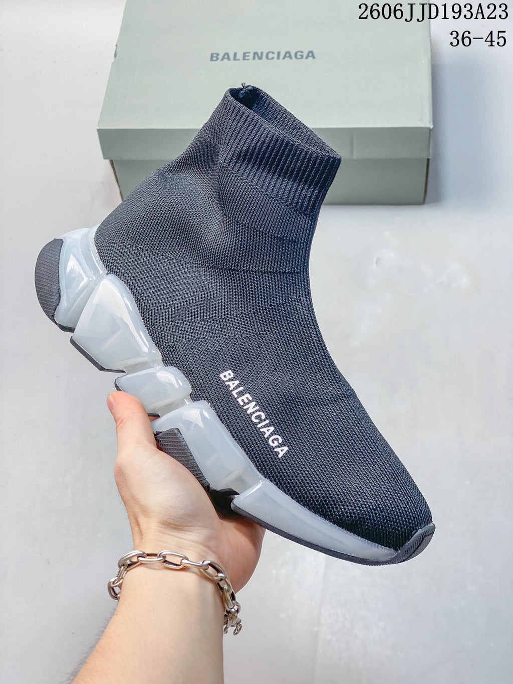 A navy Balenciaga sock-style sneaker with a translucent segmented sole and white accents, shown from the side.