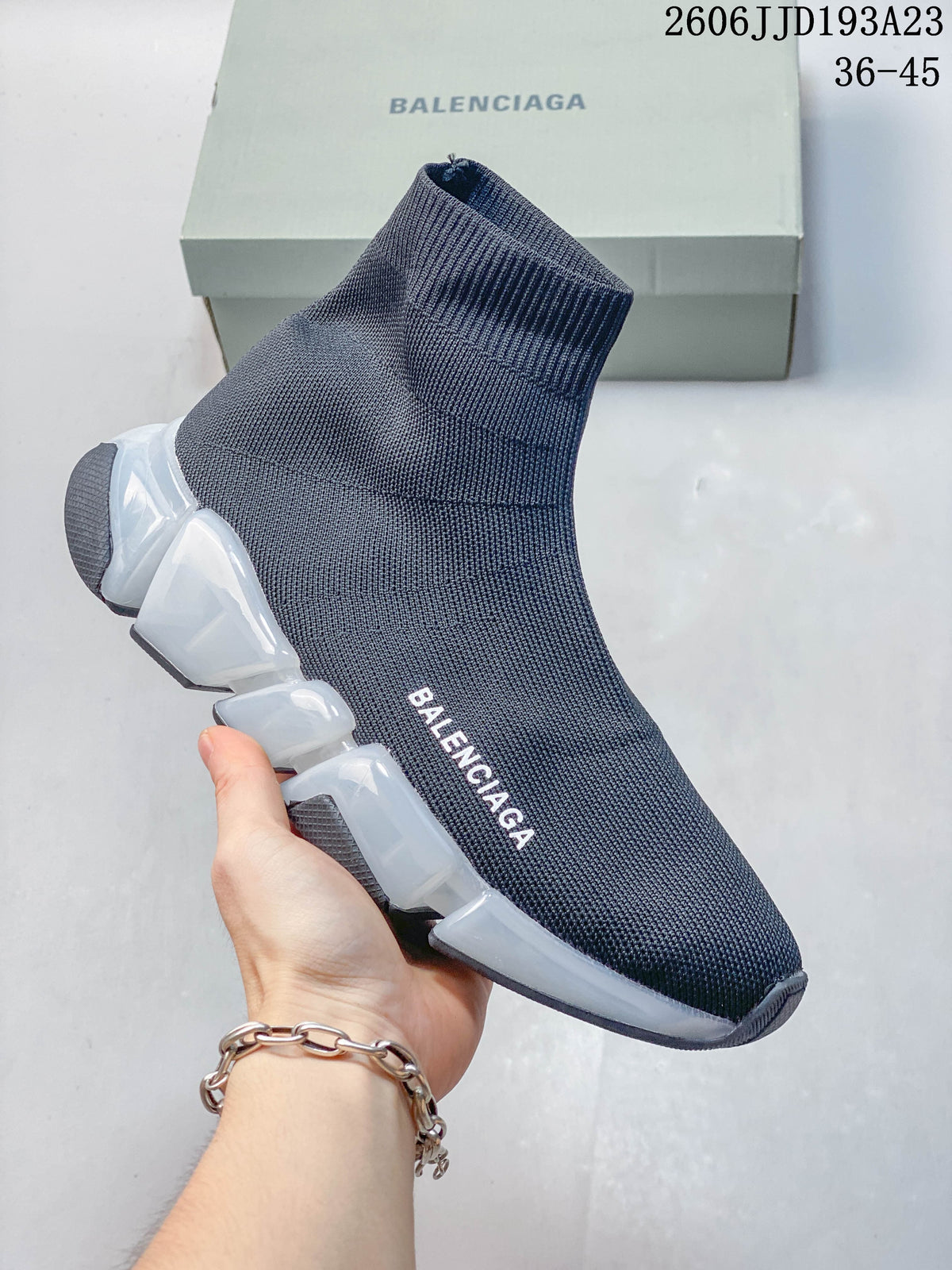 A navy Balenciaga sock-style sneaker with a translucent segmented sole and white accents, shown from the side.
