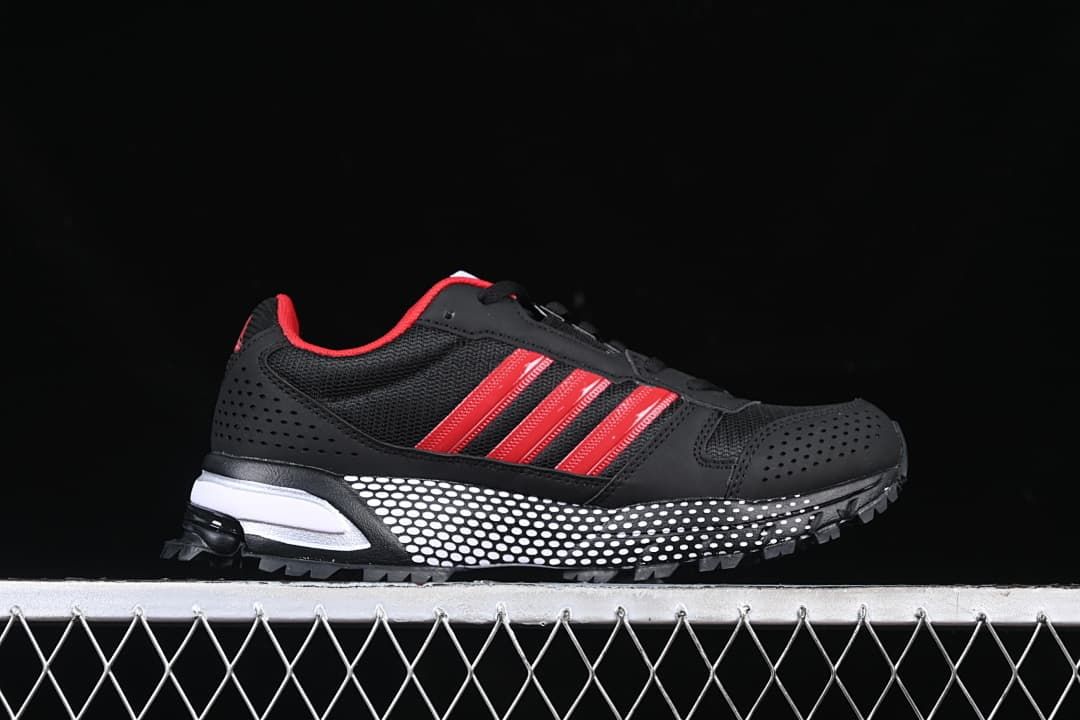 Side profile of the black sneaker with red stripes and dotted midsole.
