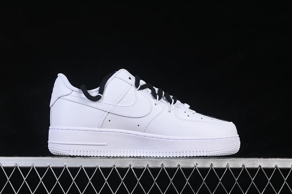 Side profile of the white low-top sneaker with a black lace detail visible.