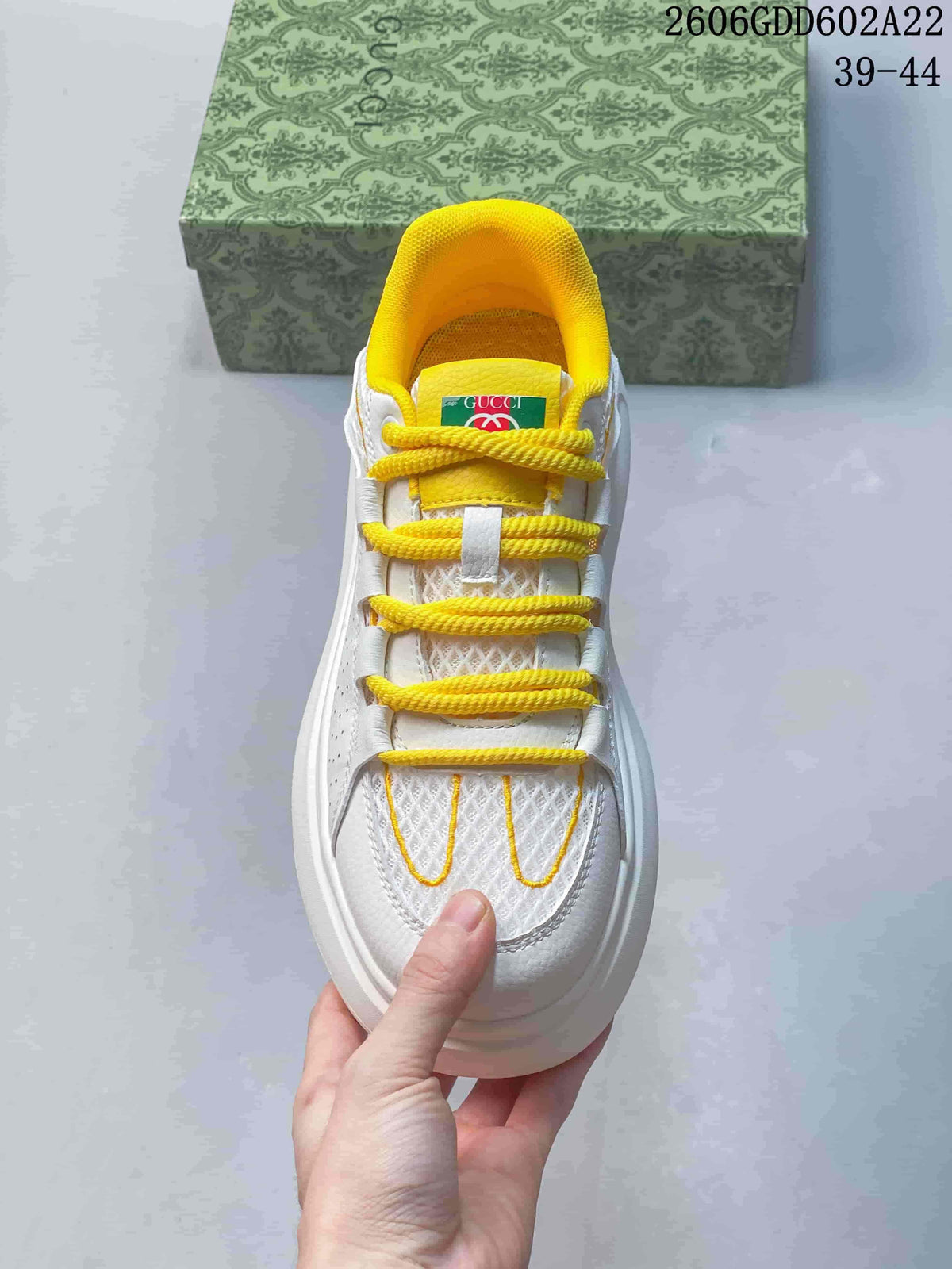 Top view showing yellow laces and collar on the white sneaker