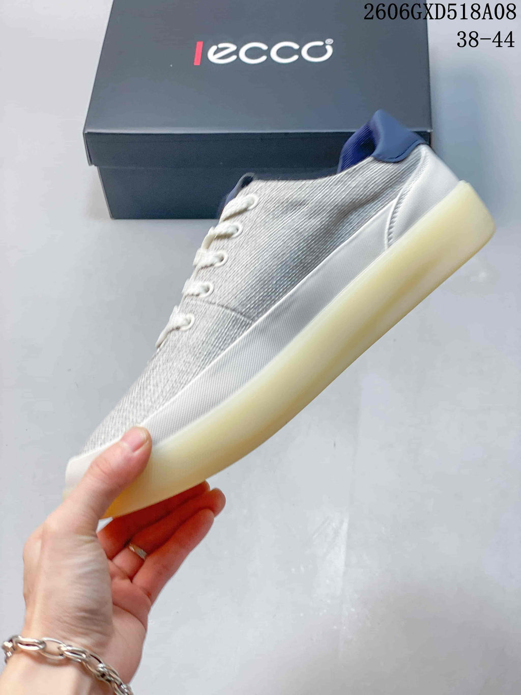 Side view of a gray lace-up sneaker with white trim and a thick pale outsole.