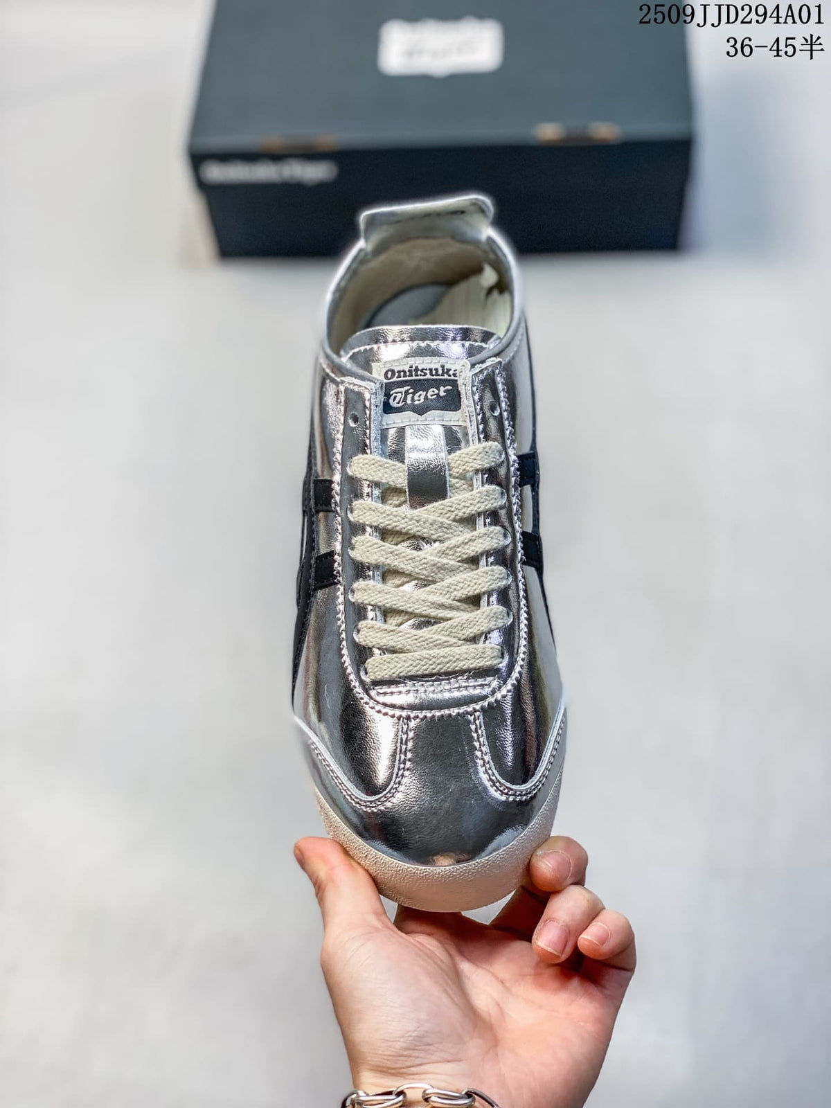 Front view of the silver sneaker with cream laces and a branded tongue label.