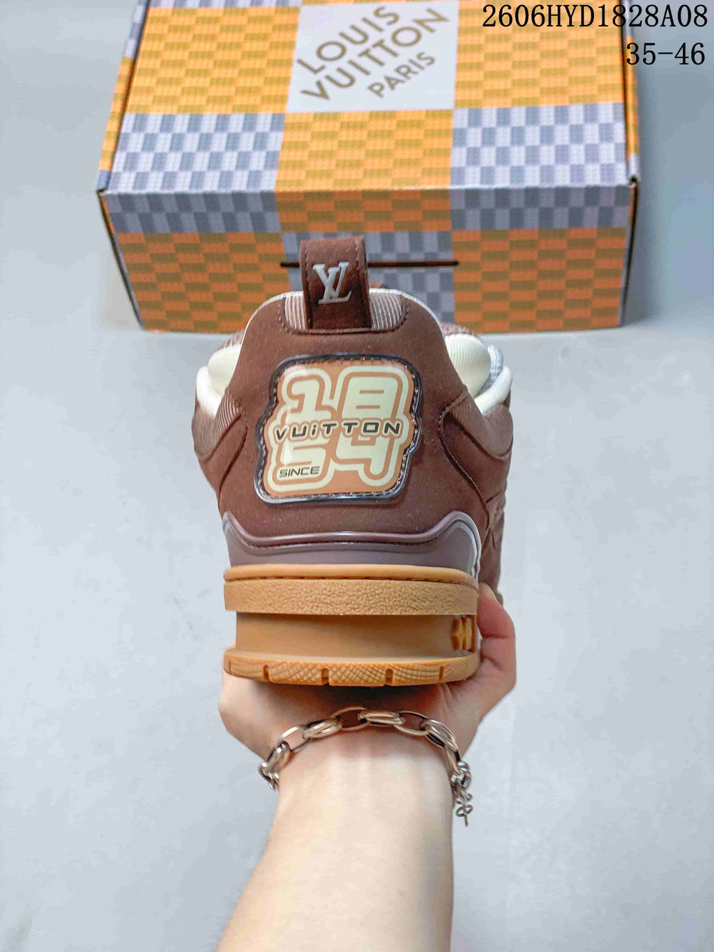 Rear view of a brown Louis Vuitton Trainer sneaker with branded heel detailing