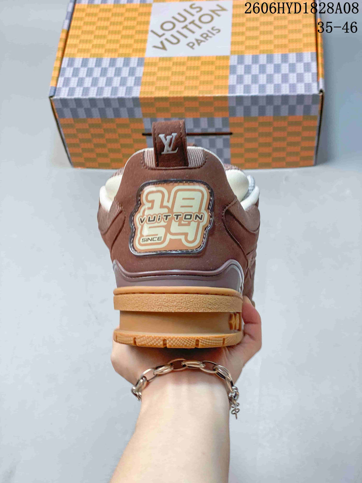 Rear view of a brown Louis Vuitton Trainer sneaker with branded heel detailing