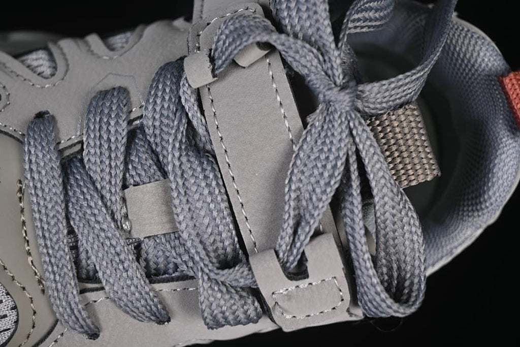 Close-up of grey laces threaded through the shoe’s lace supports.