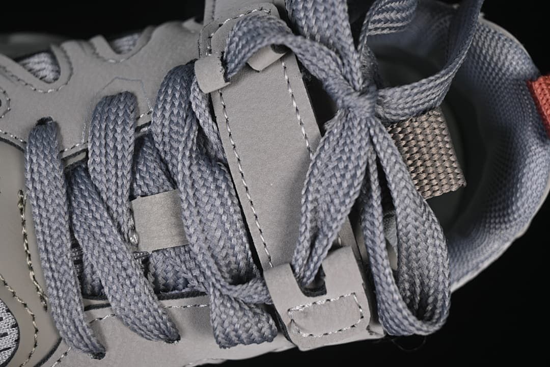Close-up of grey laces threaded through the shoe’s lace supports.