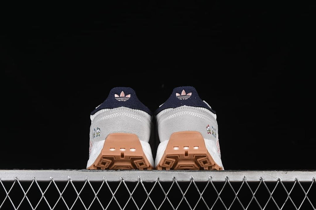 Rear view of both sneakers showing their heel details and gum-colored outsole