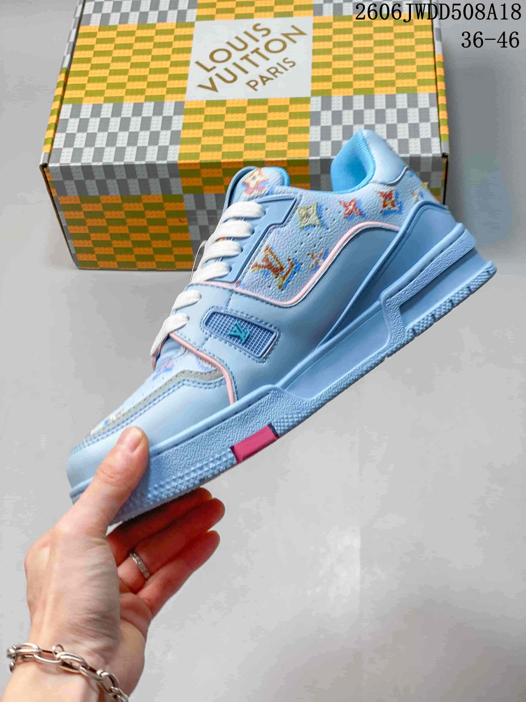 Side view of the blue low-top sneaker with patterned panels and pink trim