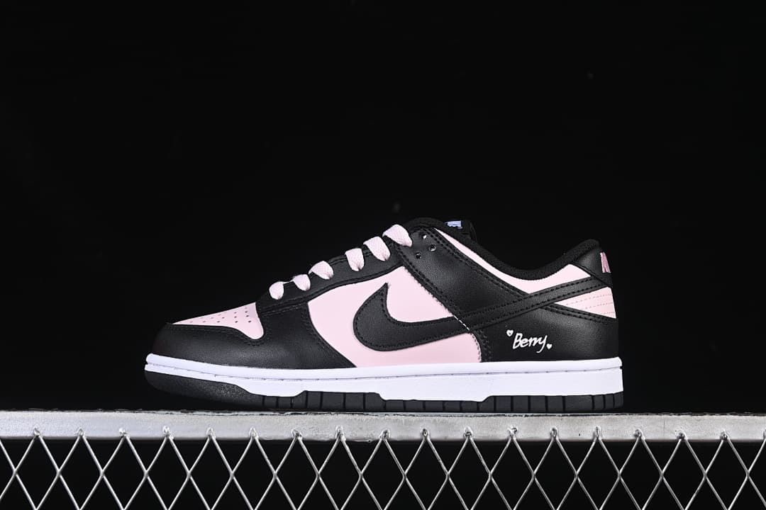 Side view of a black and pale pink low-top sneaker with a Swoosh and small Berry heel graphic.