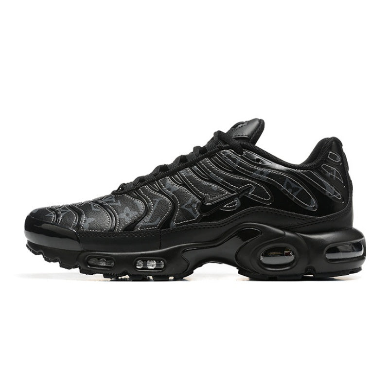 Black Nike Air Max Plus sneaker with a dark patterned upper.