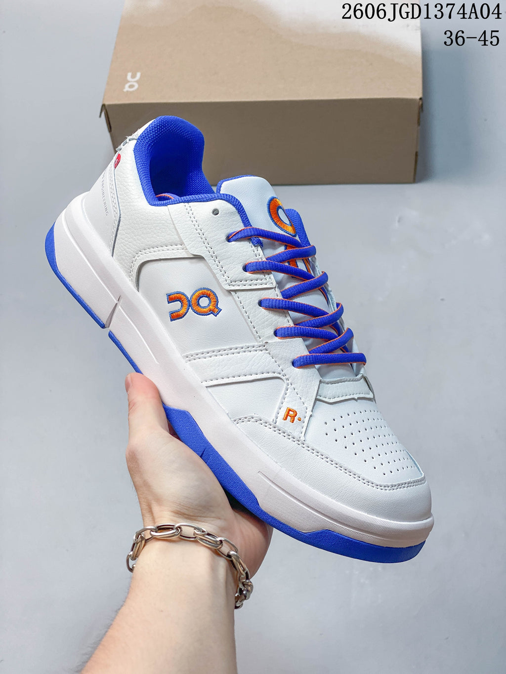 Angled side view of the white sneaker with blue outsole accents and orange logo details
