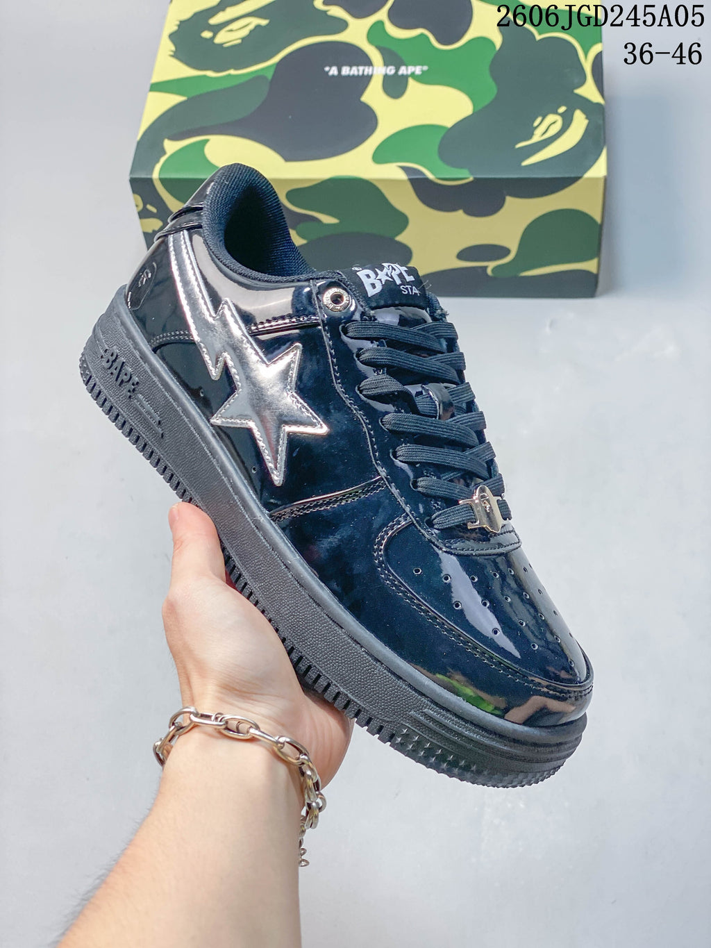 Angled side view of a glossy navy sneaker with a silver star panel and dark sole