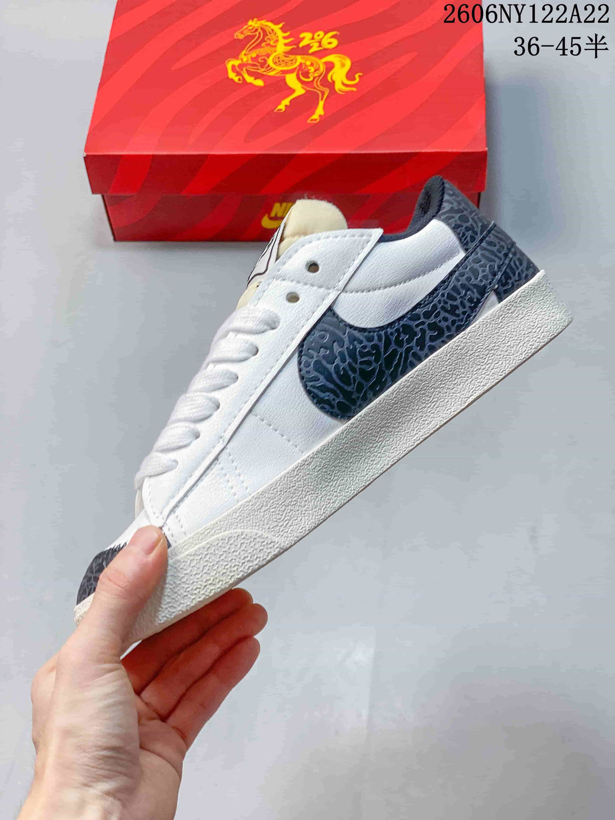 Side view of the low-top sneaker with a dark gray patterned Swoosh and heel accents.