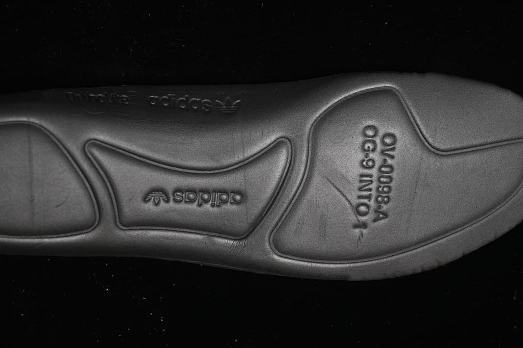 Close-up of the black outsole with embossed branding and molded details