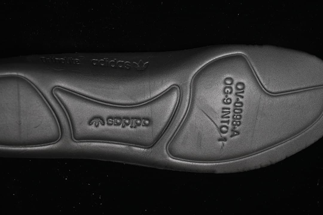 Close-up of the black outsole with embossed branding and molded details