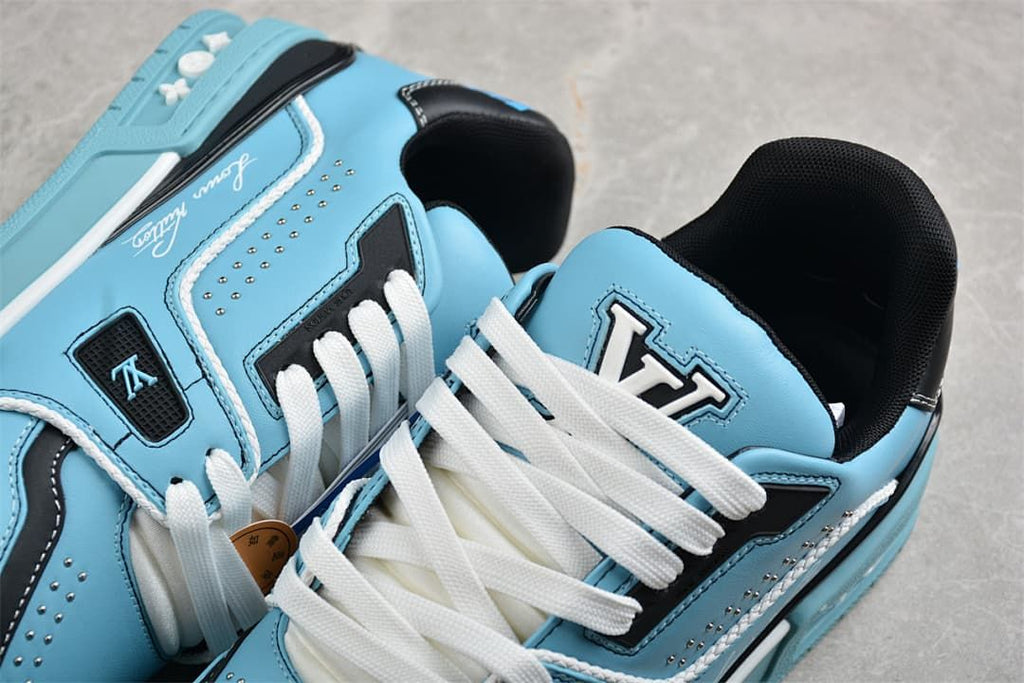 Close-up of blue LV Trainer sneakers showing white laces, tongue branding, and navy panels
