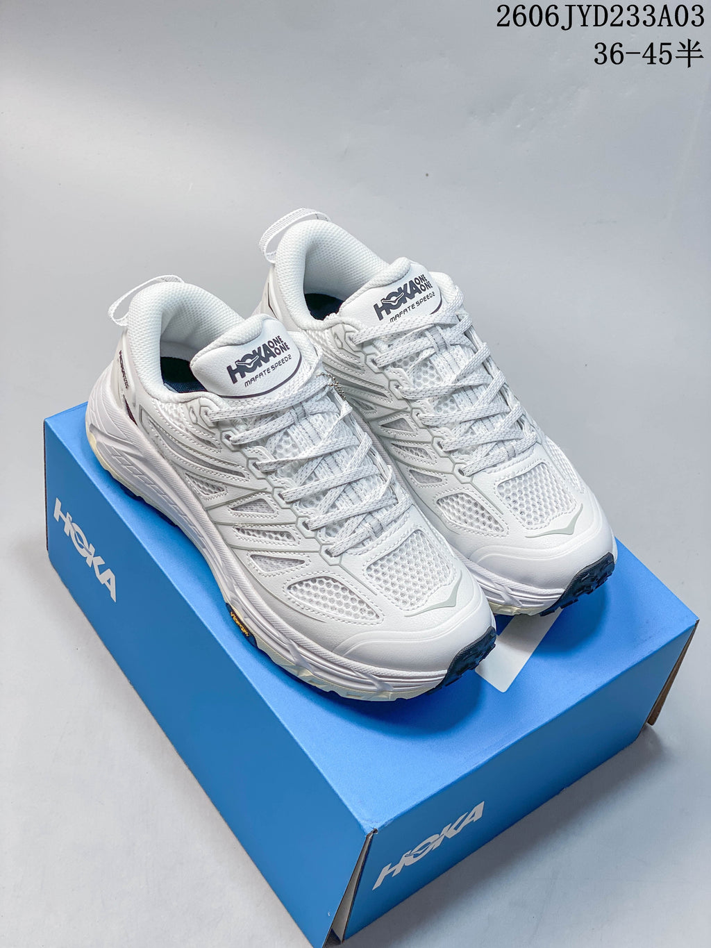 Pair of white HOKA Mafate Speed shoes displayed on a blue shoe box