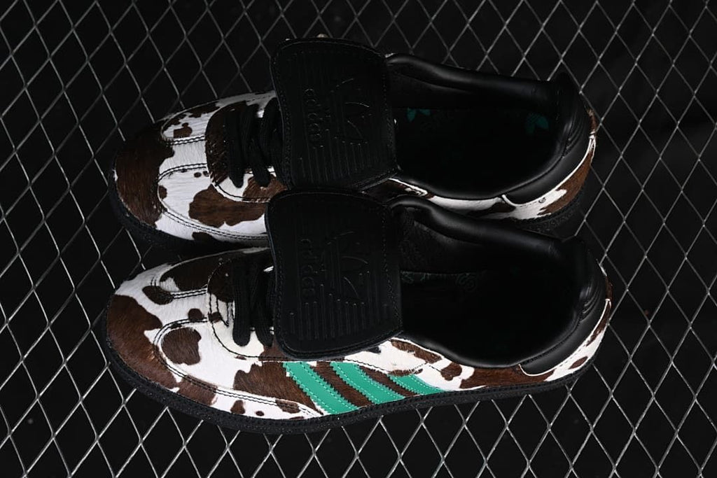 Overhead view of the pair showing the cow-print uppers, green stripes and black tongue flaps