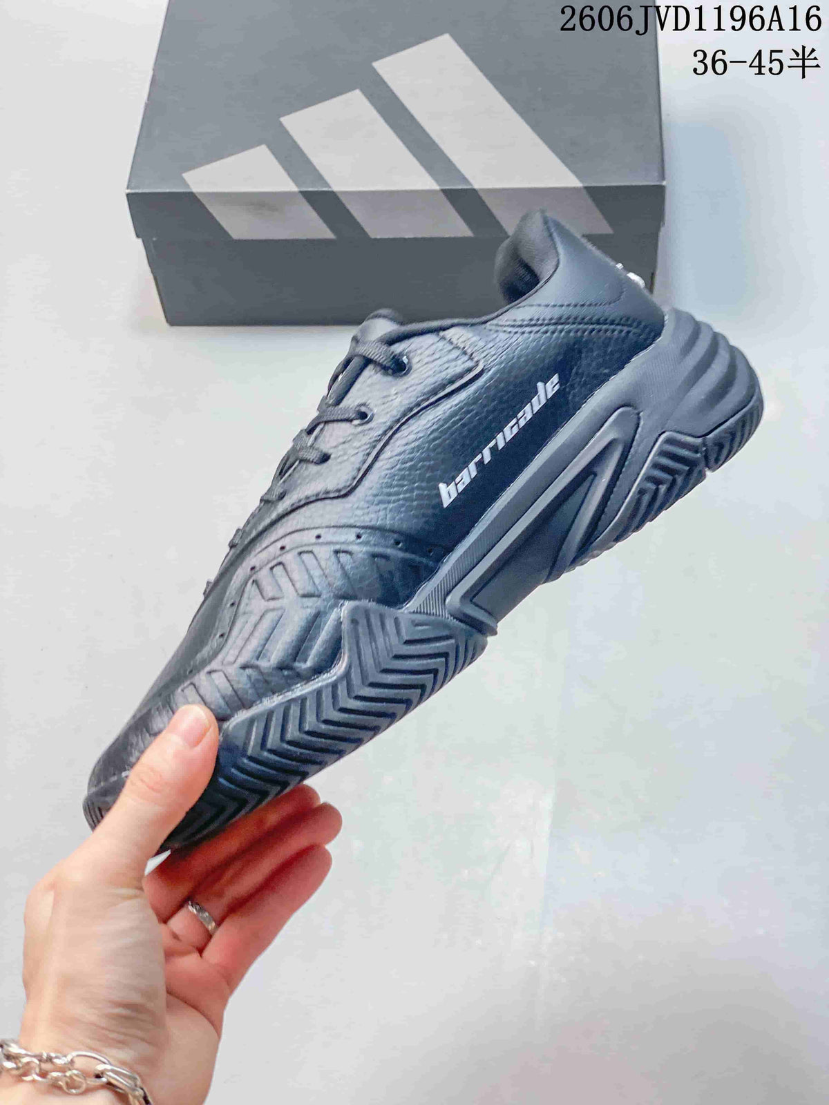 Side view of a dark grey tennis shoe with patterned outsole
