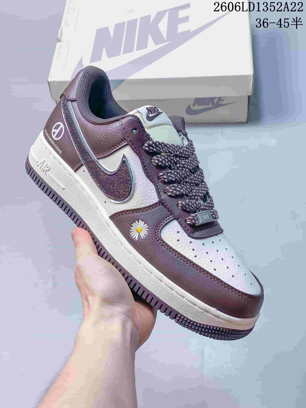 Mauve and white low-top sneaker with patterned laces, glitter-effect Swoosh and daisy embroidery.