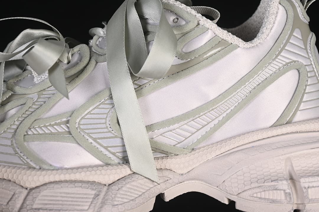 Close-up of layered side panels and broad ribbon laces