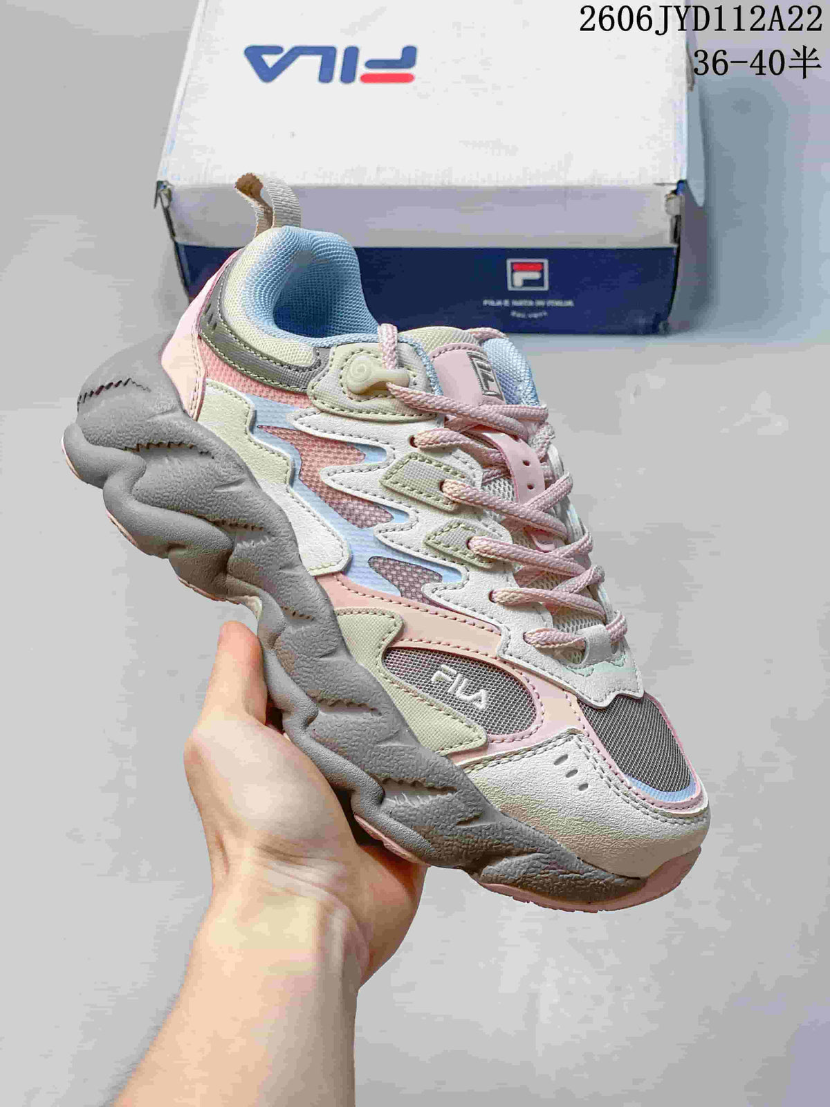 Angled side view of a pastel pink, grey, and off-white FILA FUSION Arceus sneaker.