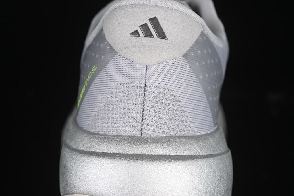 Rear view of the shoe with adidas heel branding and lime detail.