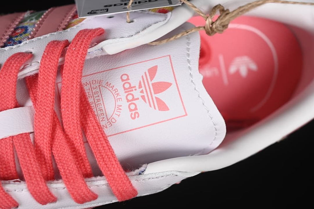 Close-up of the white tongue with adidas branding and coral-pink laces