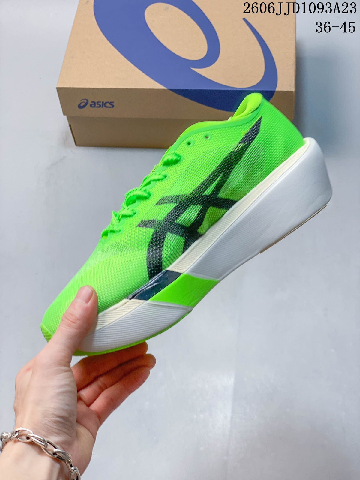 Side view of a bright green ASICS running shoe with dark stripes and a white sole
