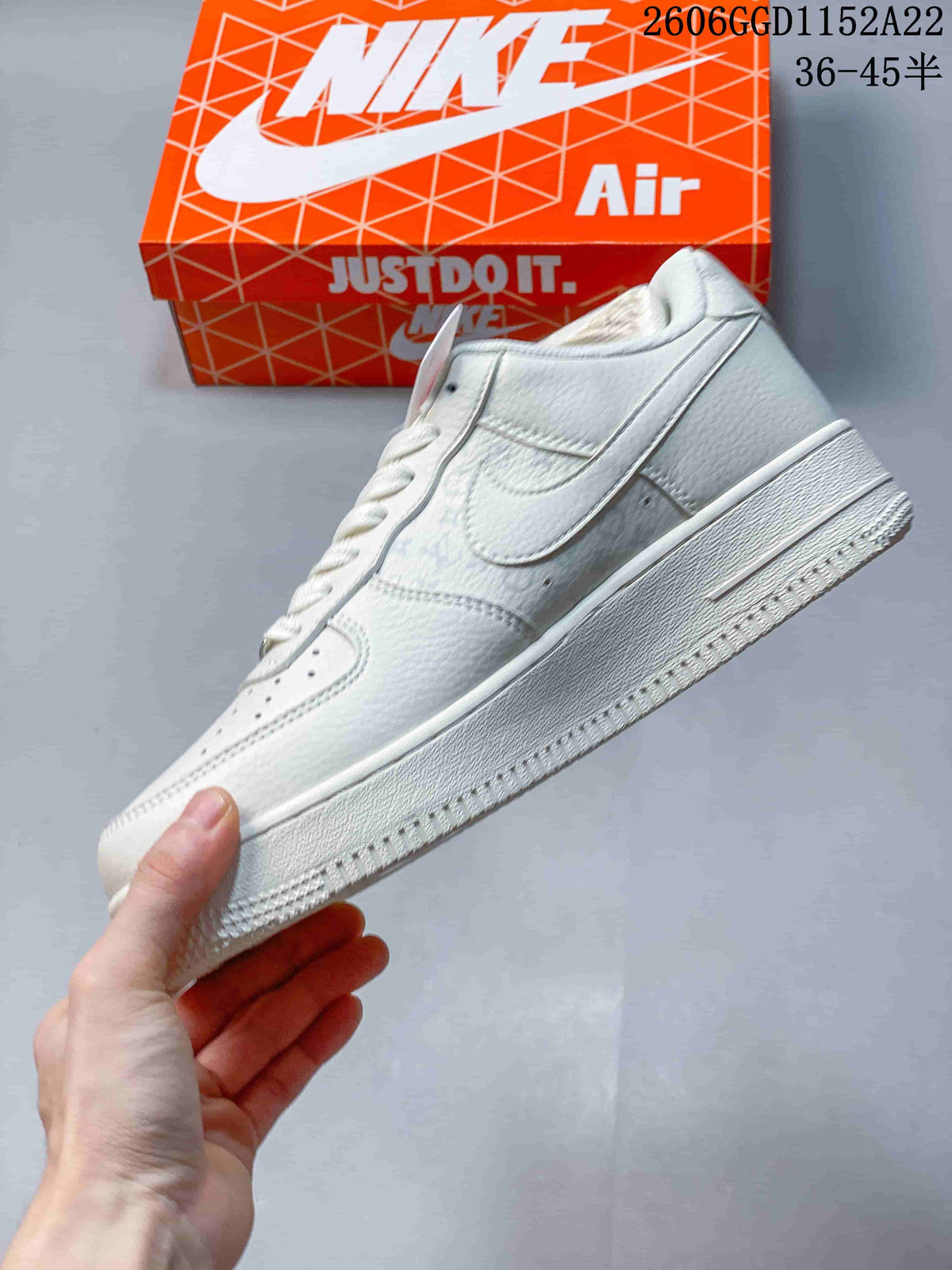 Side view of the white low-top sneaker with a textured Swoosh panel