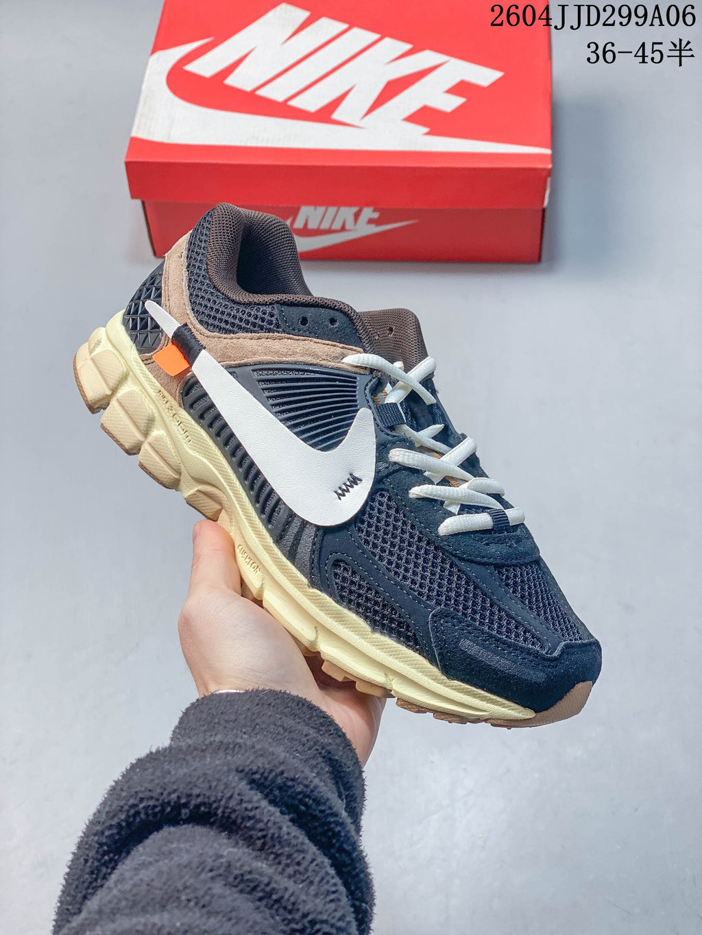 Angled side view of a navy Nike sneaker with layered panels and pale midsole