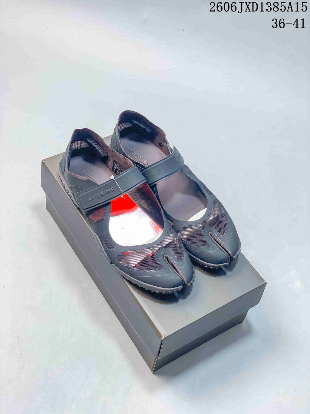 Pair of dark gray Nike Air Rift Mesh shoes with red accents and wide instep straps.